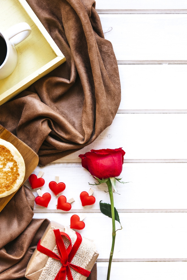 Выпечка на столе с кофе, подарком и красной розой