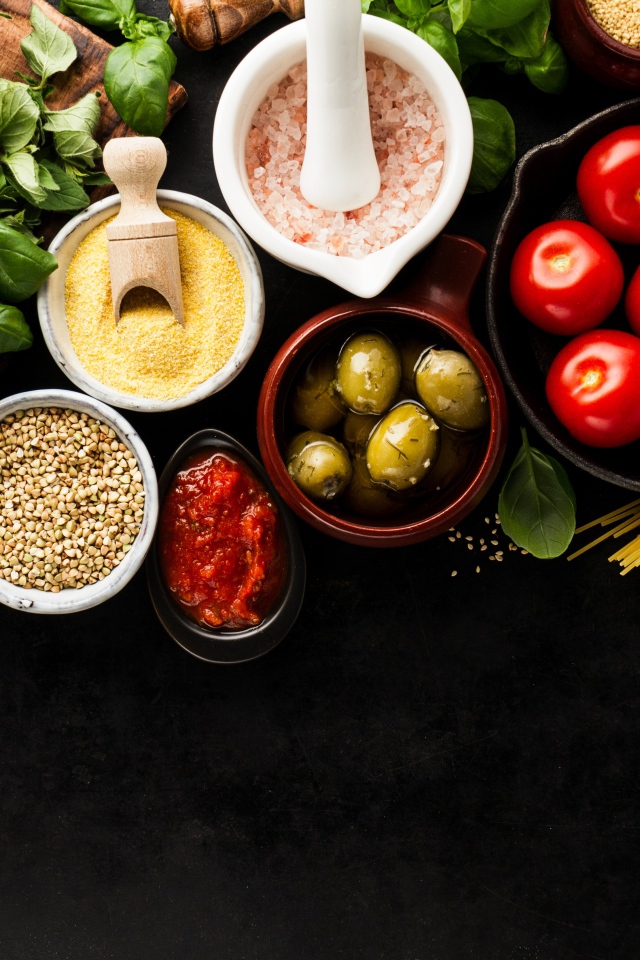 Крупы на столе с зеленью, помидорами, оливками и спагетти