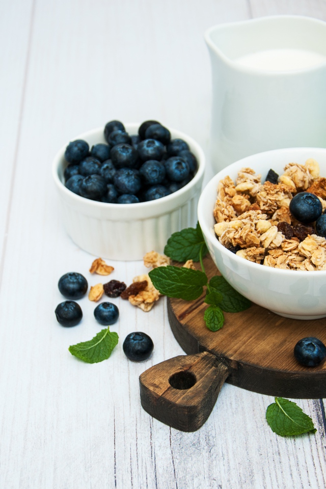 Хлопья с ягодами черники на столе с молоком