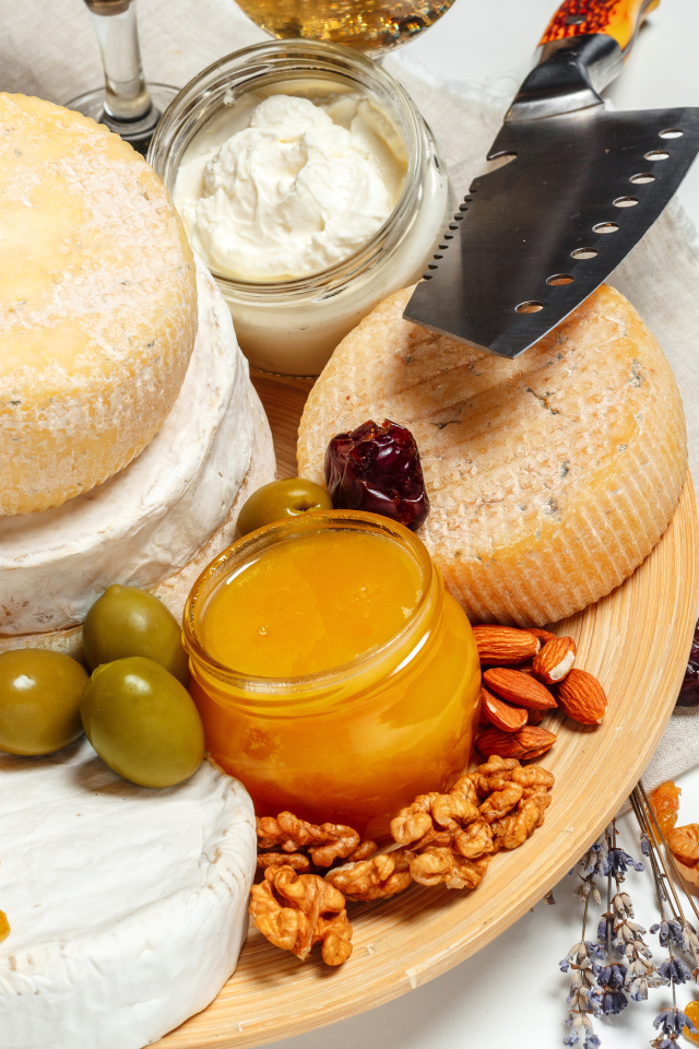 Сыр с плесенью на тарелке оливками, орехами и медом 