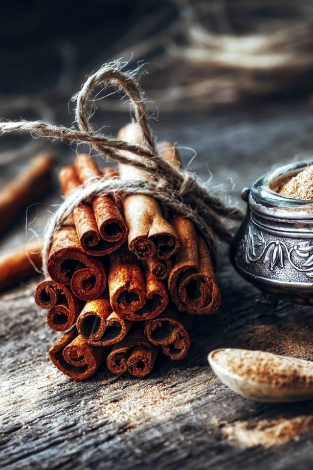 Палочки корицы на столе с молотой корицей