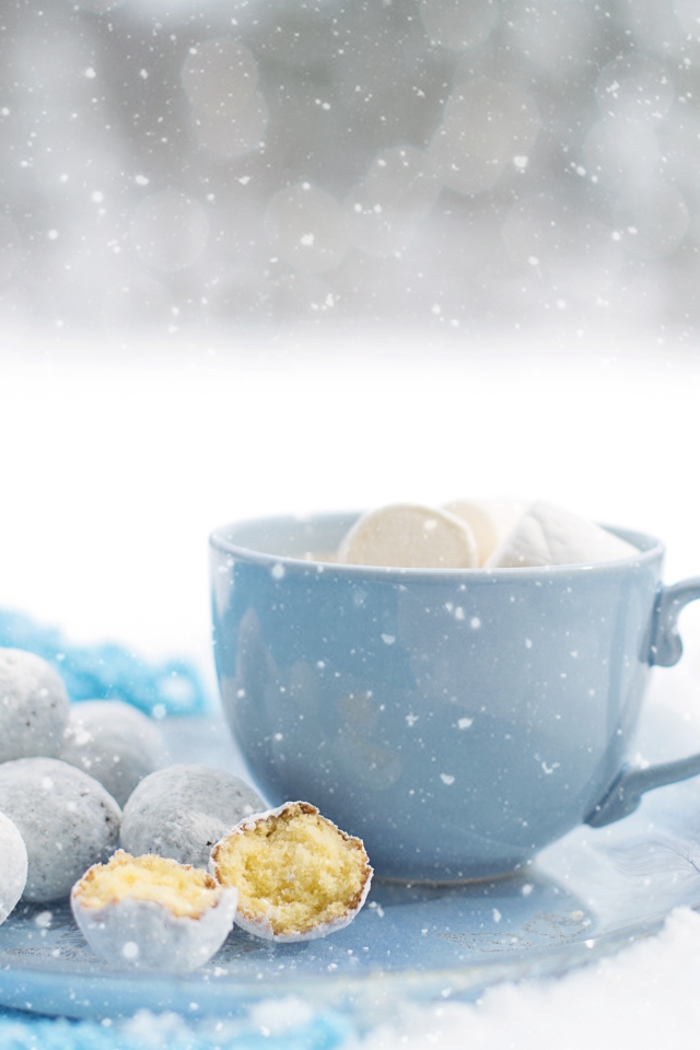 Чашка кофе с маршмеллоу на тарелке с пряниками зимой