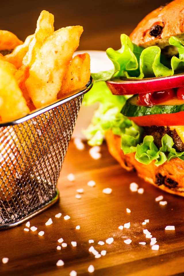 Аппетитный сочный гамбургер на доске с картошкой фри и соусом