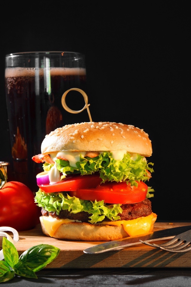 Вкусный аппетитный гамбургер на столе с пивом и картофелем фри