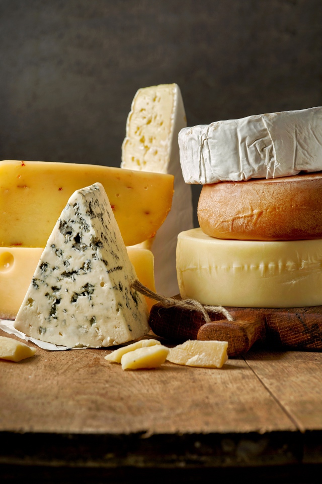 Разные виды сыра на деревянном столе 