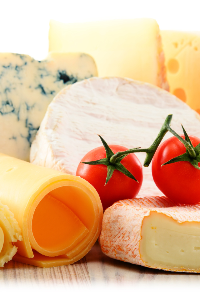 Разные виды твердого сыра на белом фоне с помидорами
