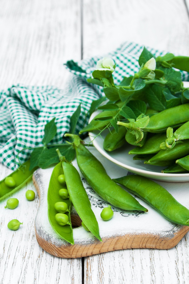 Свежий зеленый горох на столе с полотенцем