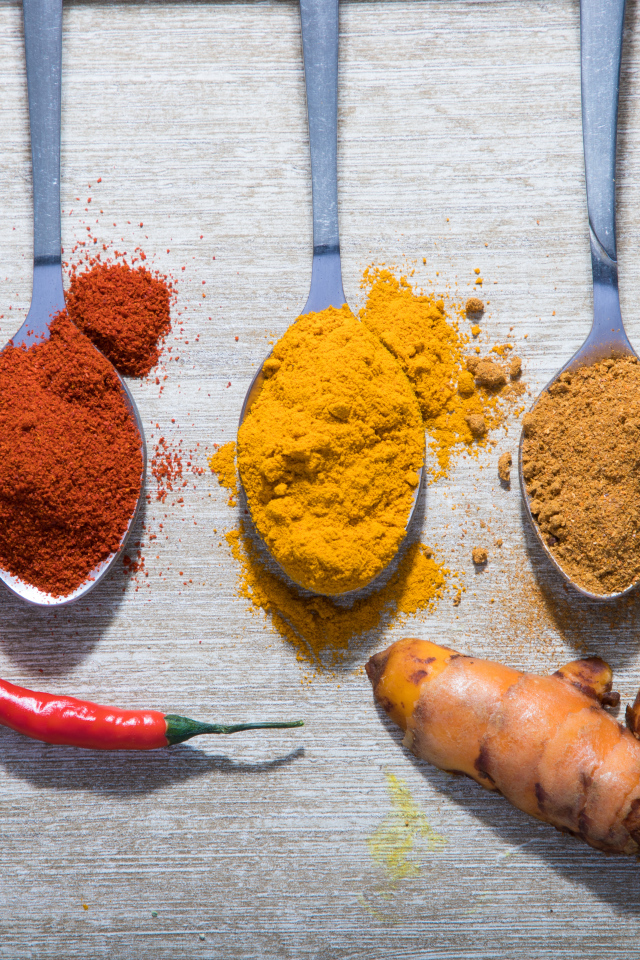 Молотые специи в ложках на столе 