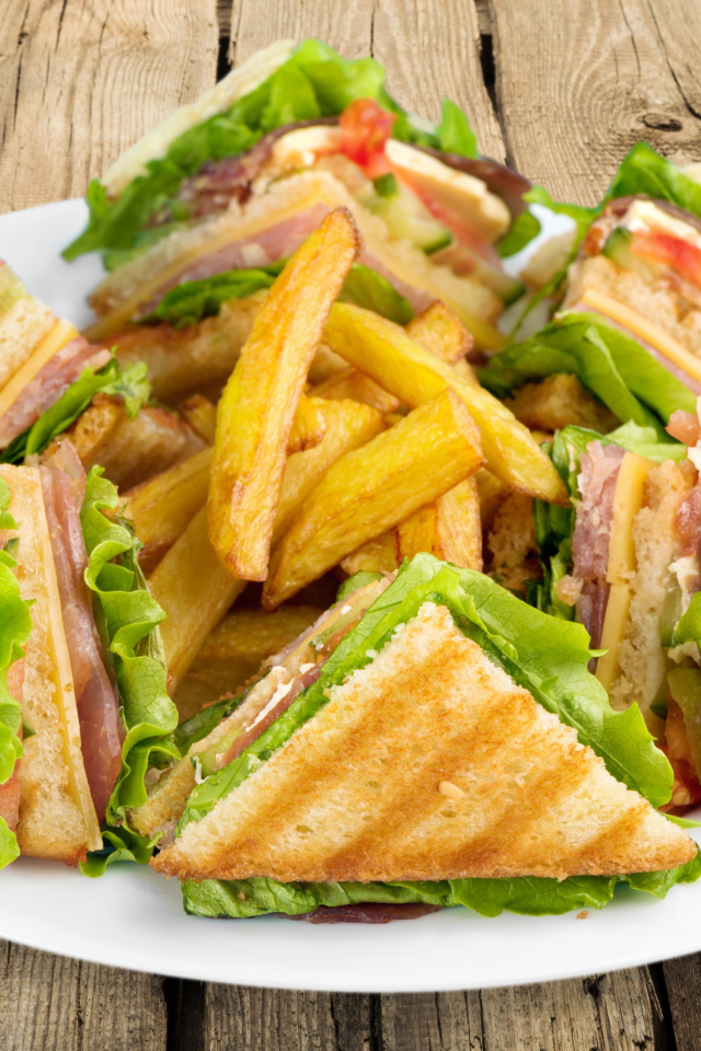 Сэндвичи с ветчиной на тарелке с картофелем фри 