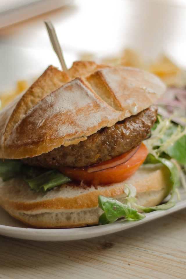 Гамбургер на тарелке с салатом 