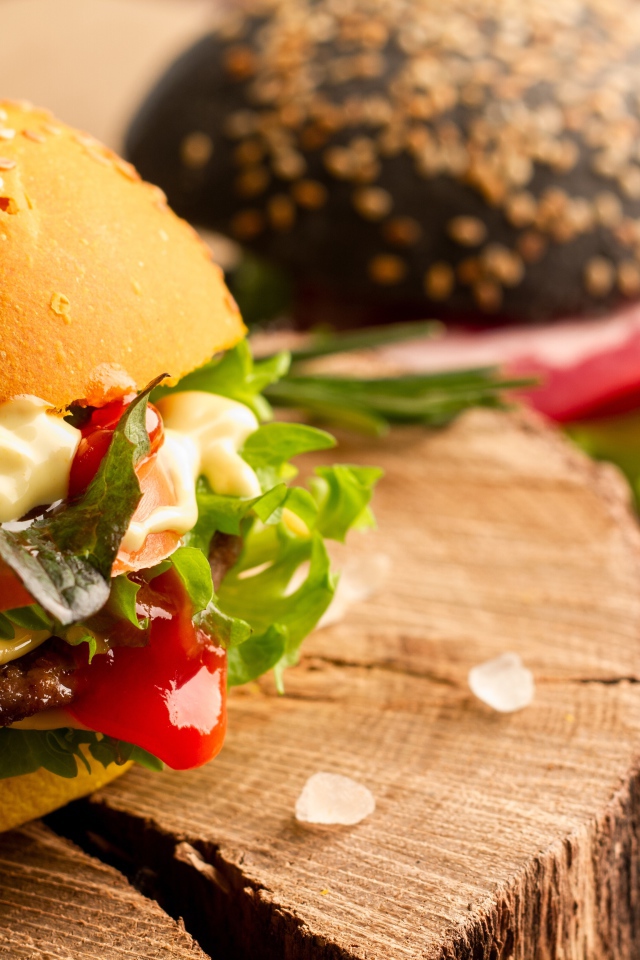 Гамбургер на деревянной доске крупным планом