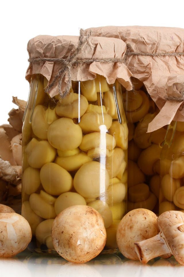 Маринованные шампиньоны в банках на белом фоне со свежими