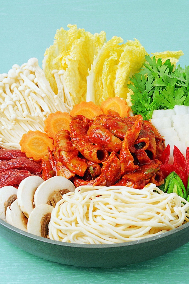 Мясо в тарелке с овощами, грибами и лапшой на голубом фоне