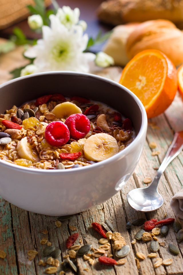 Мюсли в миске с молоком на завтрак с соком и апельсинами 