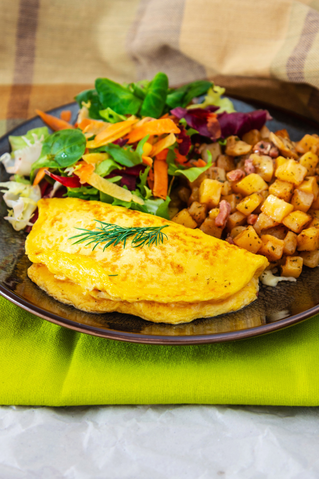 Омлет на тарелке с салатом и овощами