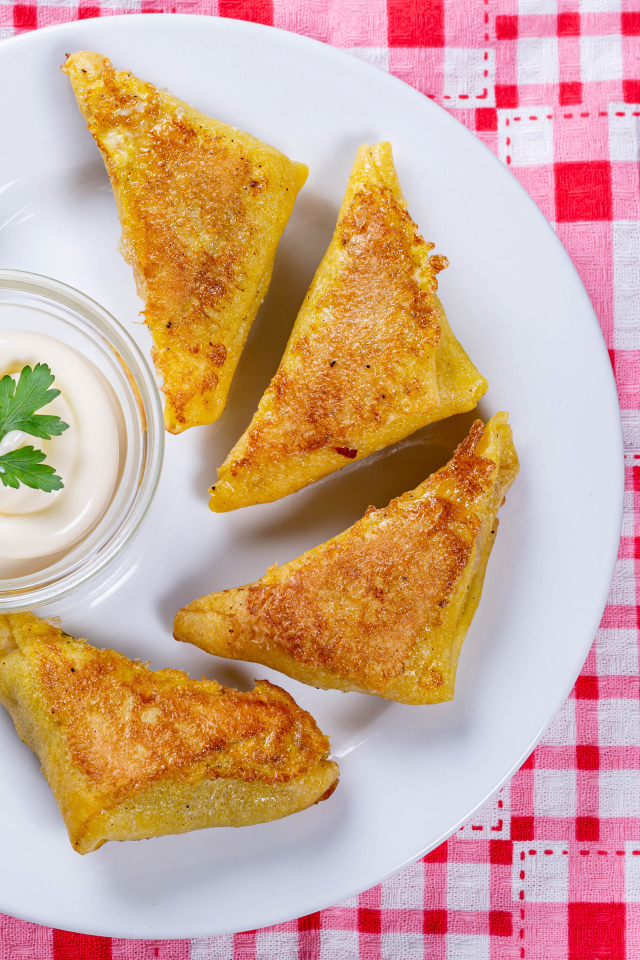 Блинчики со сметаной на столе со столовыми приборами 