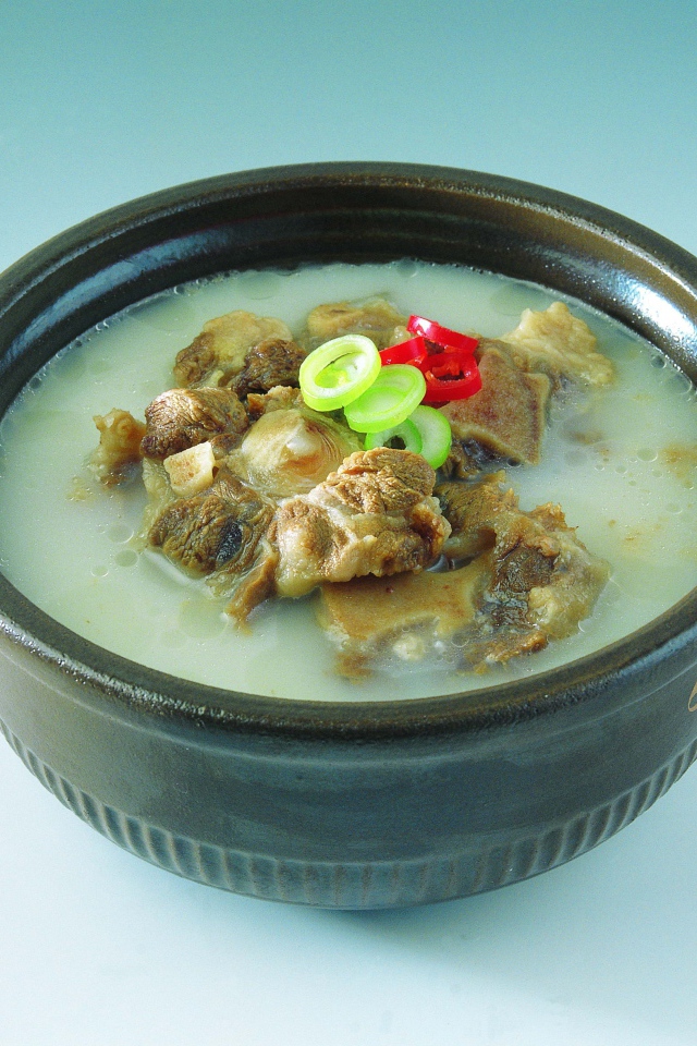 Тарелка супа с говядиной  на голубом фоне