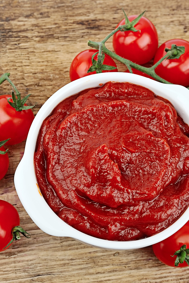 Красные спелые помидоры на столе с кетчупом