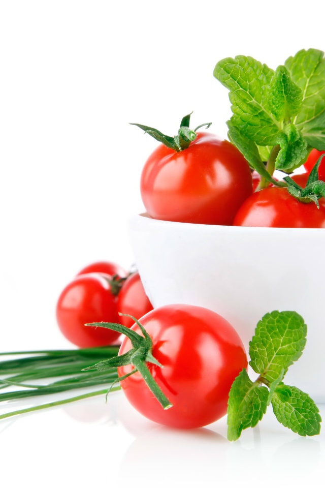 Красные помидоры с зеленым луком на белом фоне