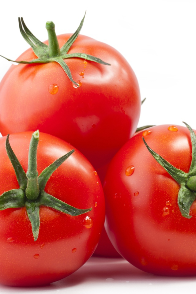 Спелые большие томаты на белом фоне
