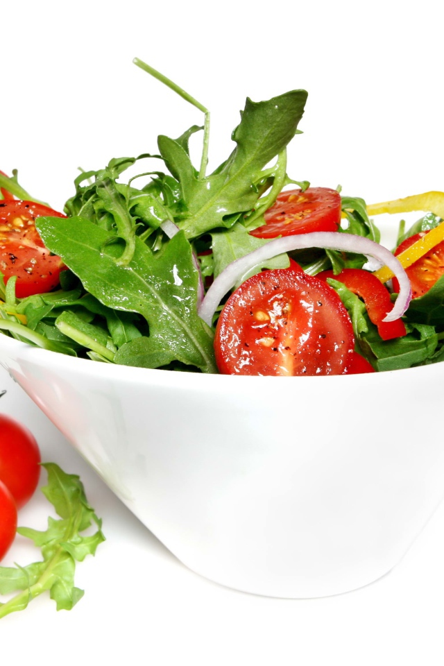 Салат с помидорами и рукколой на белом фоне