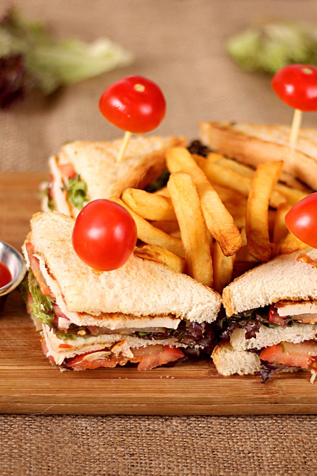 Сэндвичи на доске с картофелем фри и соусом