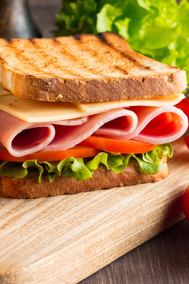 Бутерброды на столе с помидорами и листьями салата