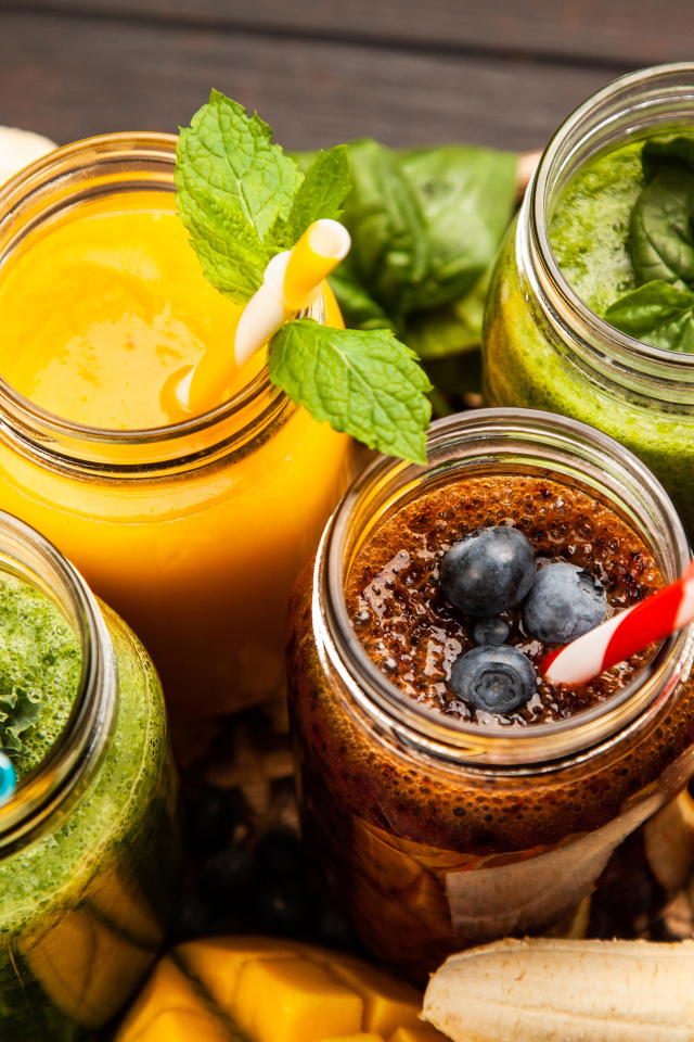 Банки со смузи на столе с бананами