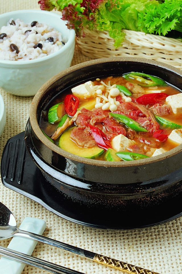 Суп с овощами и мясом на столе с закусками 