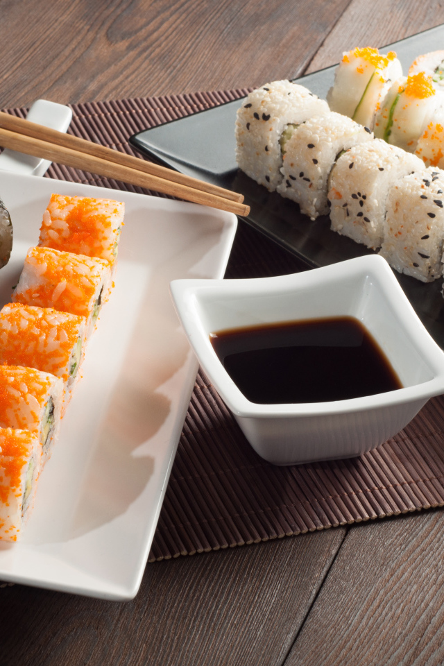Суши на столе с соевым соусом и палочками