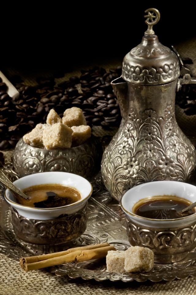 Чайный сервиз с кофе на столе с зернами