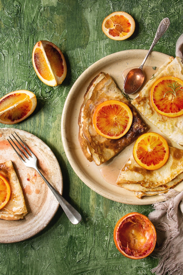 Тонкие блинчики с апельсинами на столе