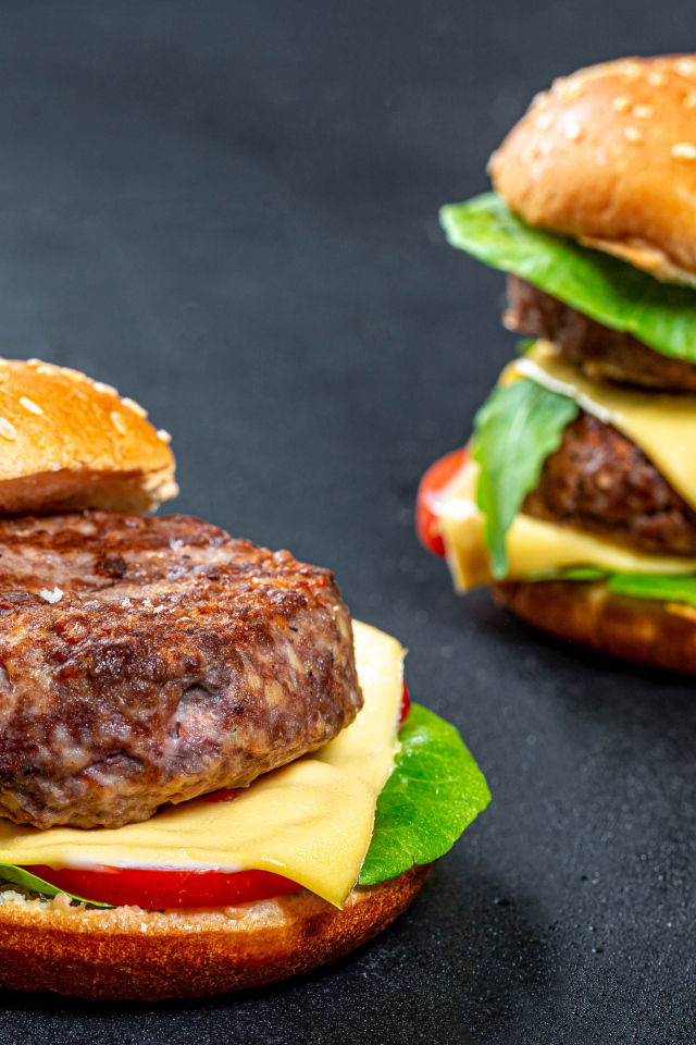 Два гамбургера с большой котлетой на столе