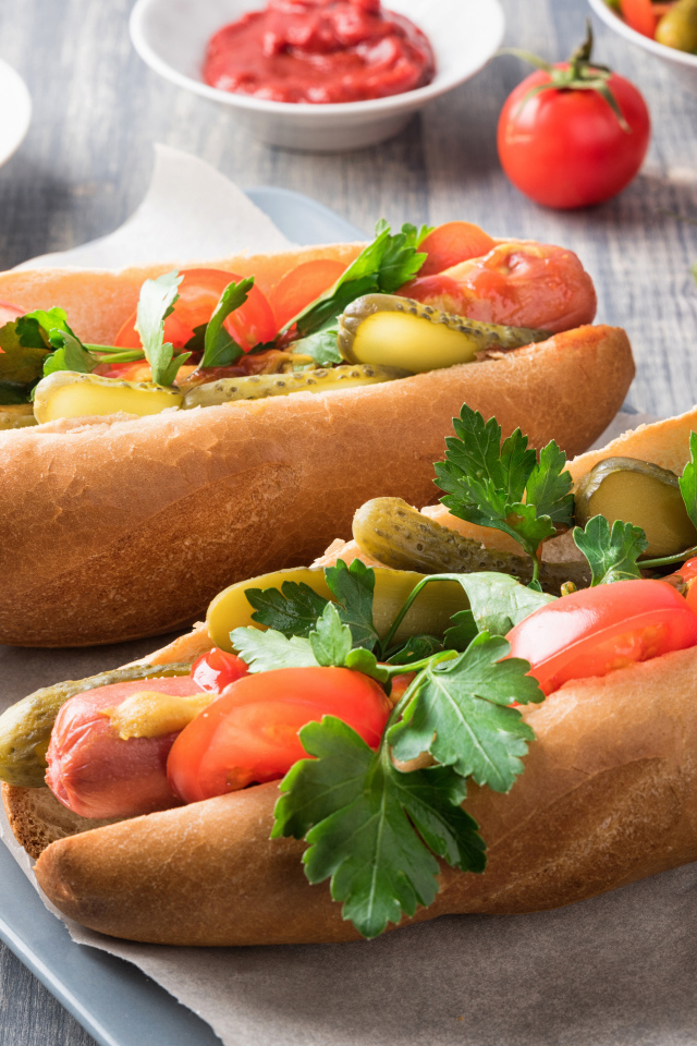 Два хотдога с сосиской, огурцами и помидорами