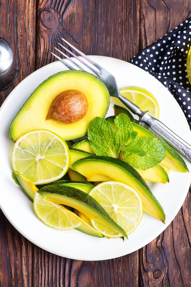 Авокадо и лимон нарезанный кусочками на тарелке