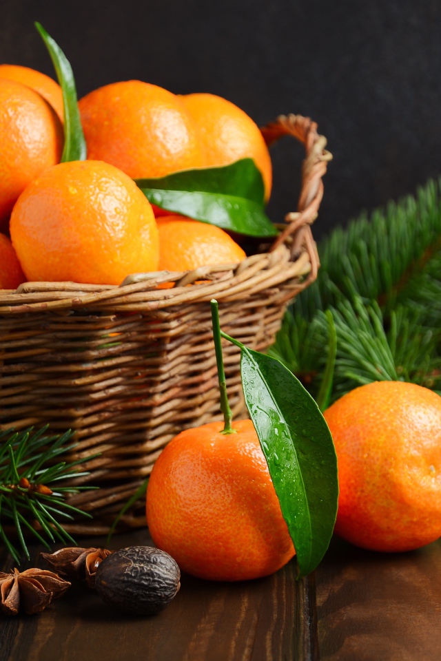 Корзина с мандаринами на столе со специями