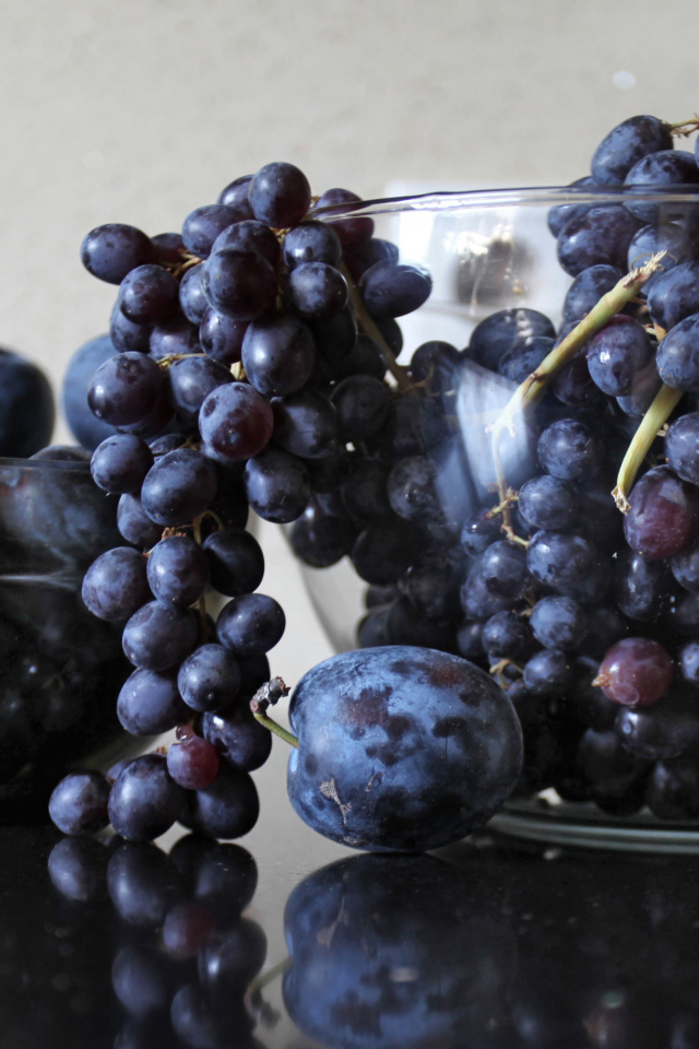 Синий виноград с синими сливами на столе