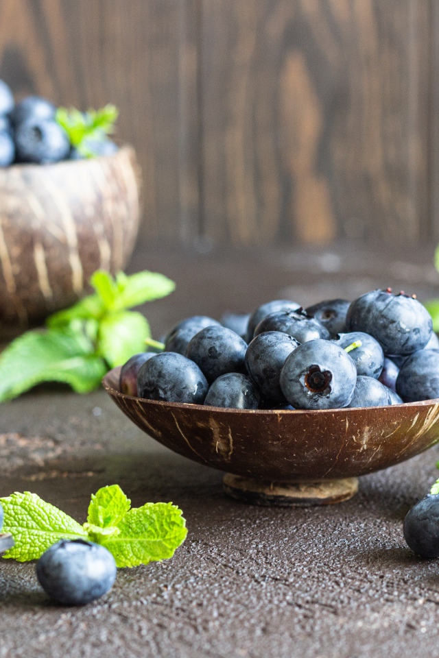 Ягоды черники стоят на столе в посуде