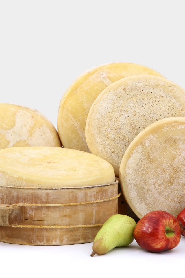 Сыр на столе с грушами, яблоками и виноградом