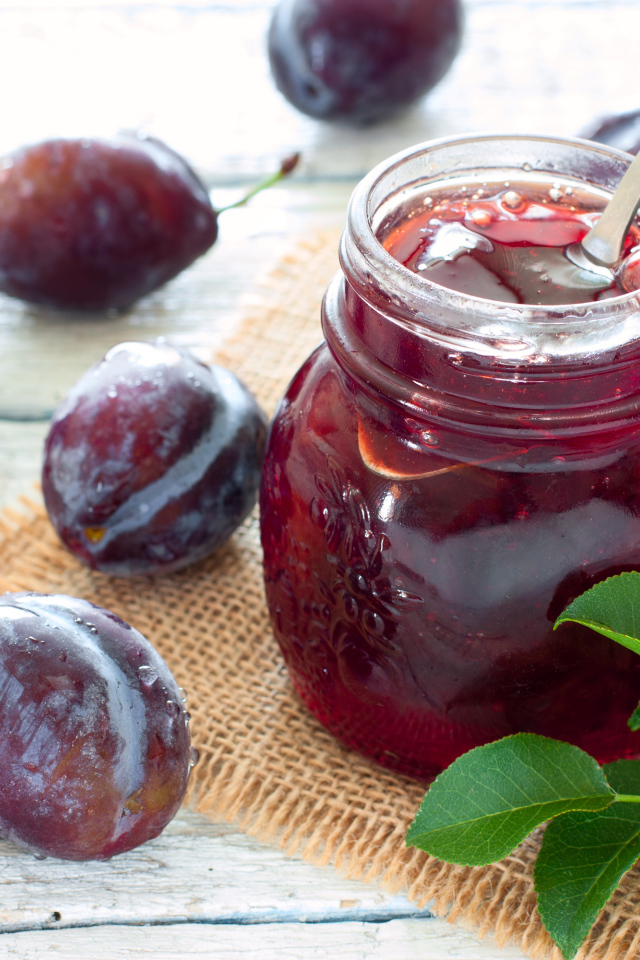 Джем в банке на столе со сливами