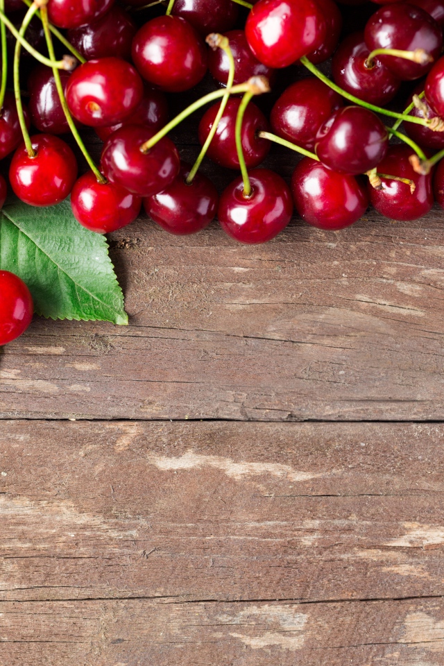 Красные спелые вишни на деревянном столе