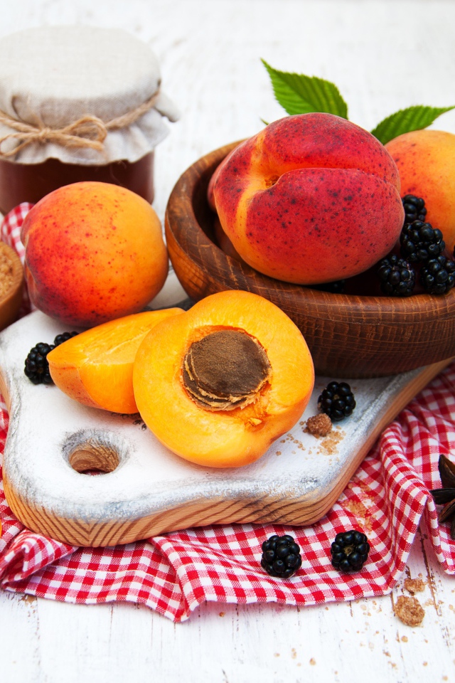 Спелые сочные абрикосы на столе с ягодами черники