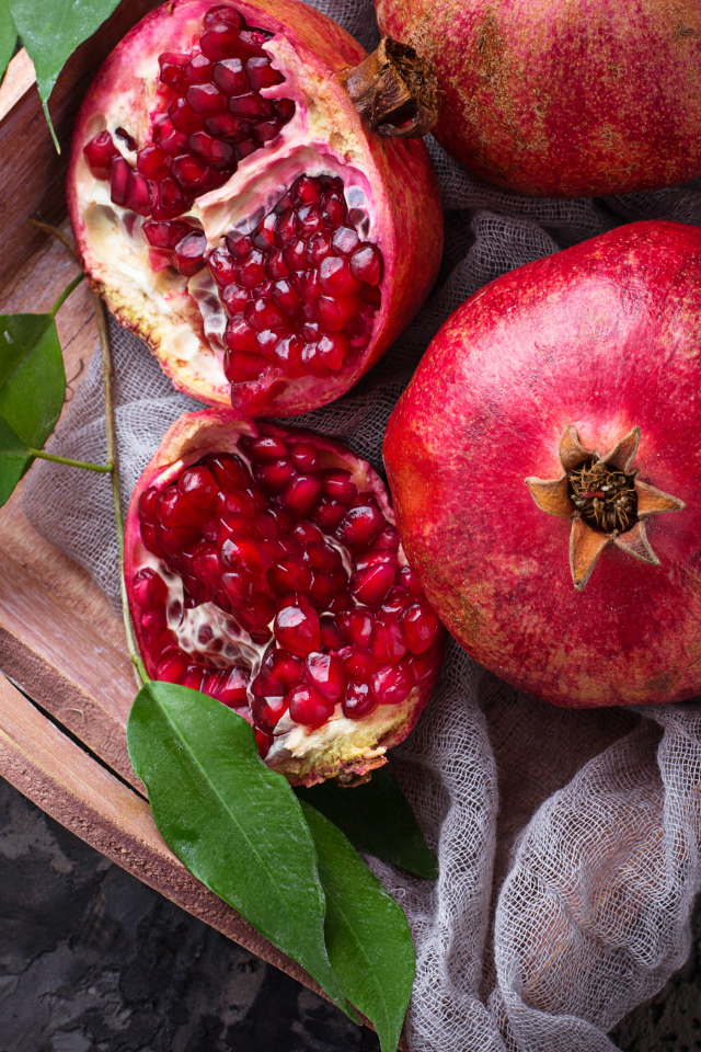 Спелые красные гранаты в деревянном ящике