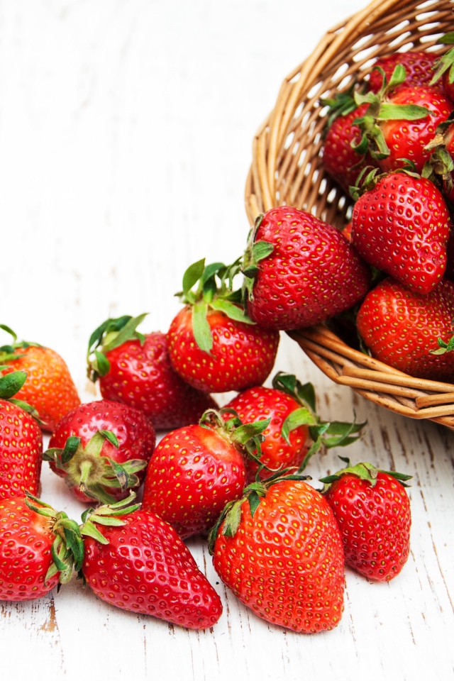 Клубника в корзине на деревянном столе