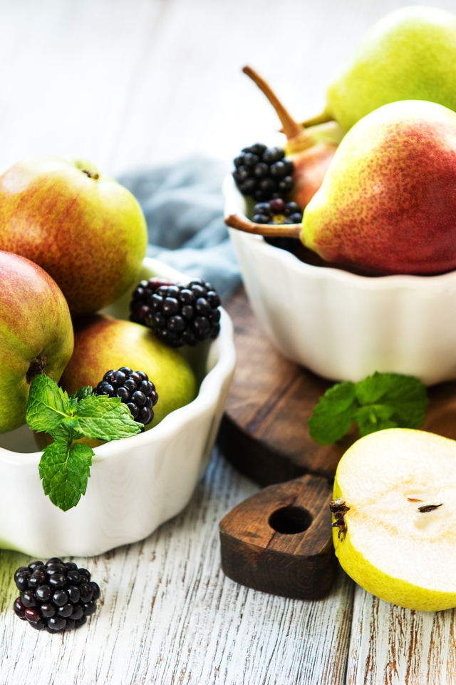 Вкусные груши на столе с ягодами ежевики