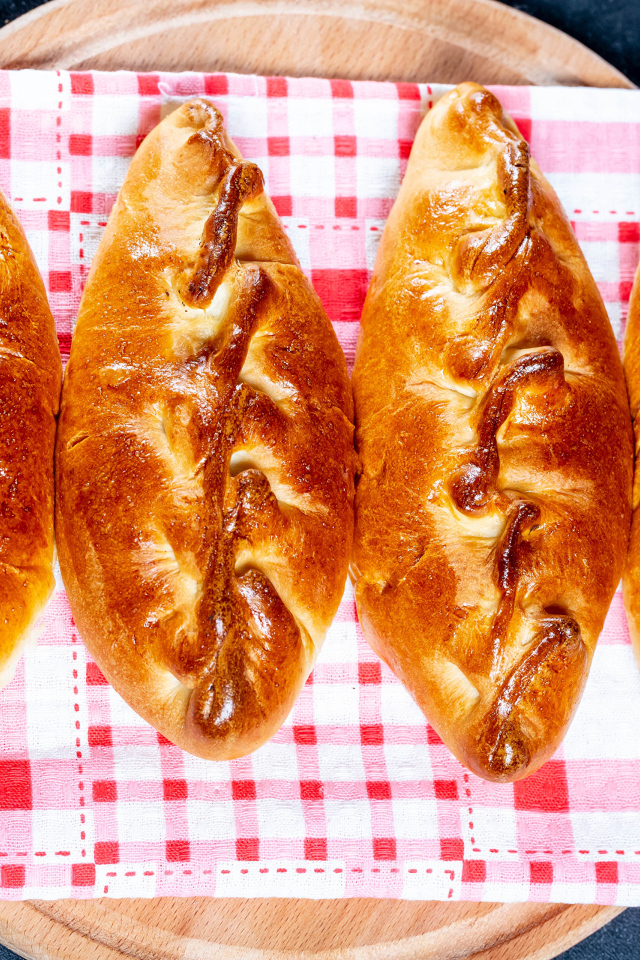 Аппетитные румяные пирожки лежат на полотенце 