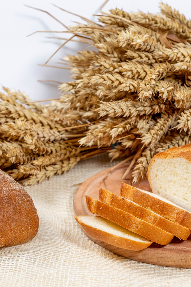 Свежий ароматный хлеб на столе с колосьями пшеницы