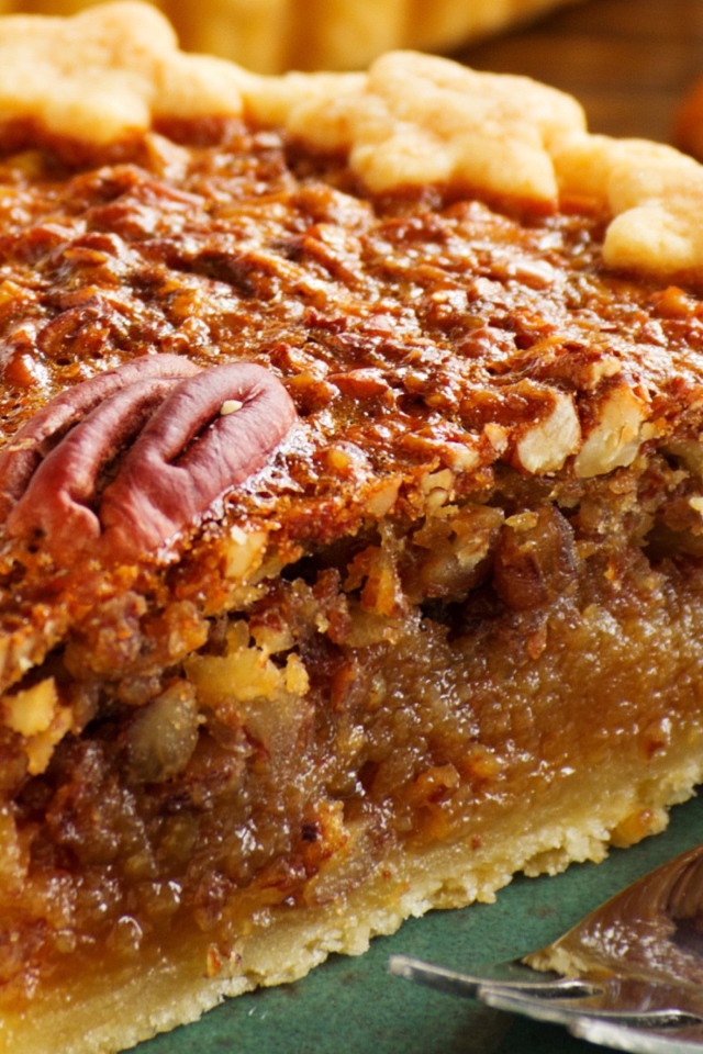 Кусок пирога с орехами на тарелке с вилкой