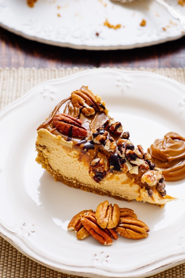 Кусок торта с орехами на белой тарелке на столе с кофе