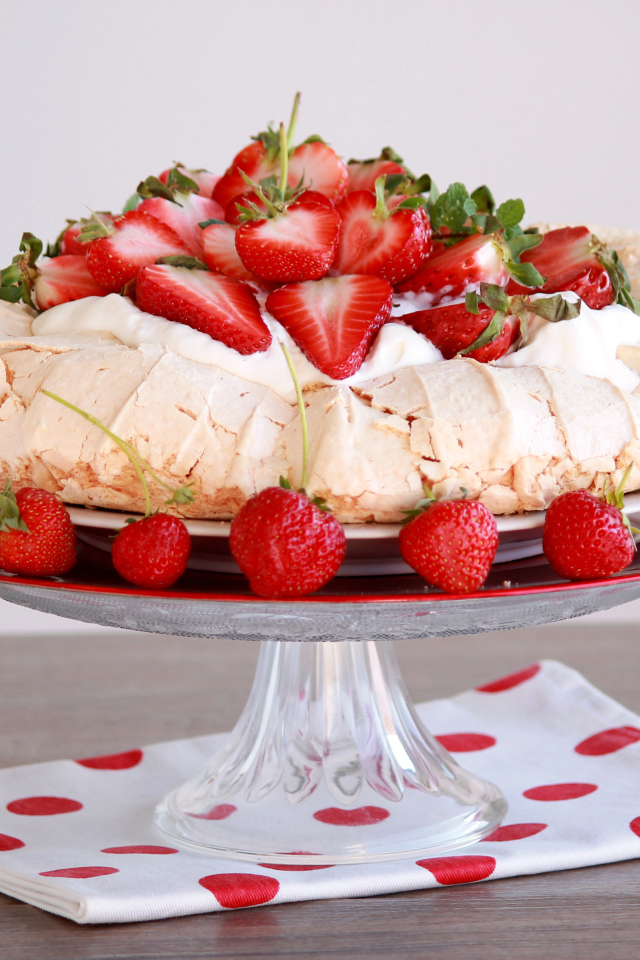 Аппетитный десерт Павлова на блюде с клубникой